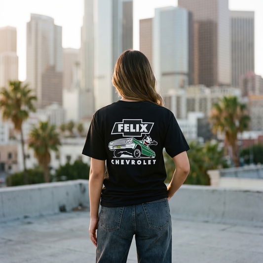 Person wearing a black t-shirt with 'Felix Chevrolet' design, standing on a rooftop with a cityscape in the background.